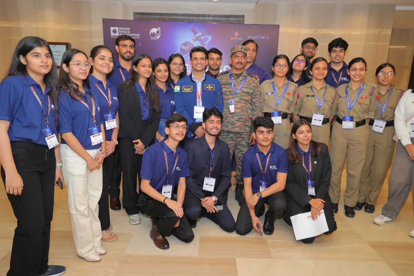 Students and cadets wearing IISC lanyards pose with an astronaut and an Army officer at IISC 2025